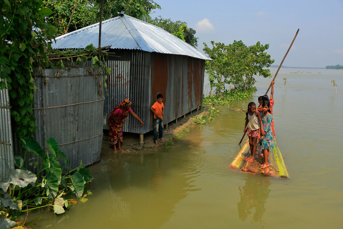 Children using a boat made out of a banana tree makes their way to a flood shelter in Northern Bangladesh.